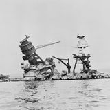 Die gesunkene "USS Arizona". Nur noch die Aufbauten ragen aus dem Wasser.