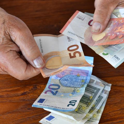 Ein älterer Mann zählt Geldscheine