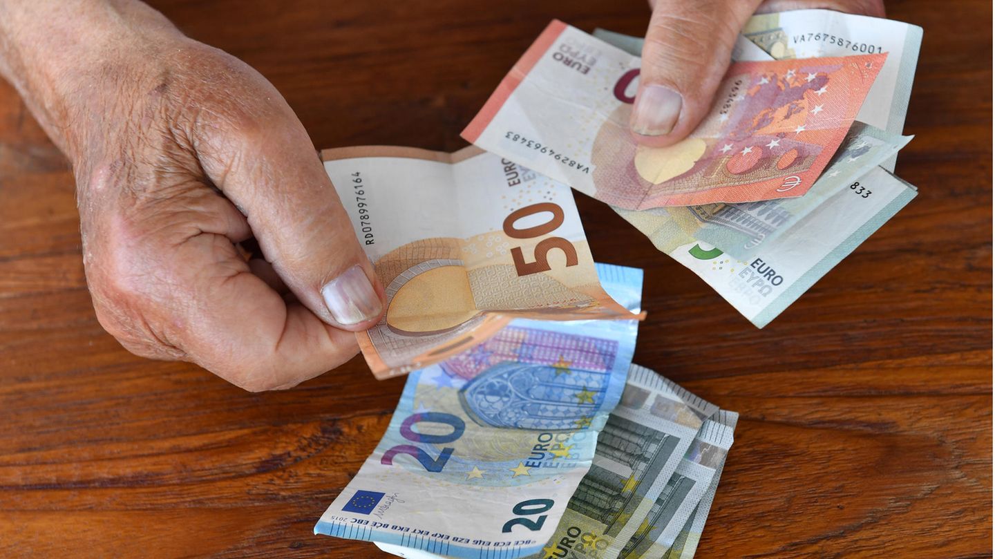 Ein älterer Mann zählt Geldscheine
