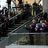 Angela Merkel steht und winkt auf der Tribüne des Bundestages