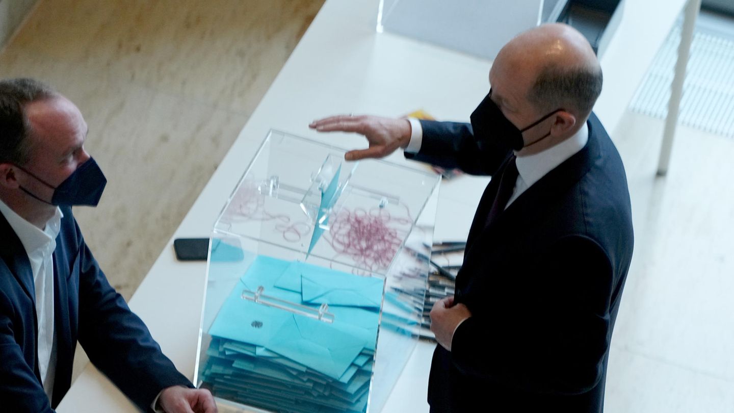 Olaf Scholz (r, SPD) gibt seine Stimme bei der Kanzlerwahl ab