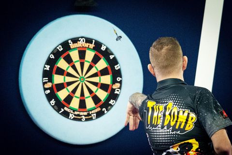 Darts Zubehör: Profispieler wirft einen Dart auf Dartboard