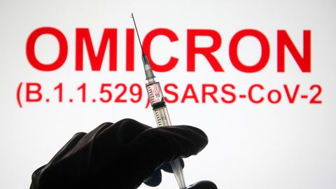 Eine Hand hält vor der Aufschrift "Omicron (B.1.1.529): SARS-CoV-2" eine Spritze hoch