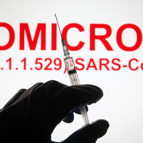 Eine Hand hält vor der Aufschrift "Omicron (B.1.1.529): SARS-CoV-2" eine Spritze hoch