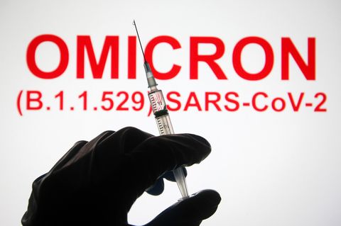 Eine Hand hält vor der Aufschrift "Omicron (B.1.1.529): SARS-CoV-2" eine Spritze hoch