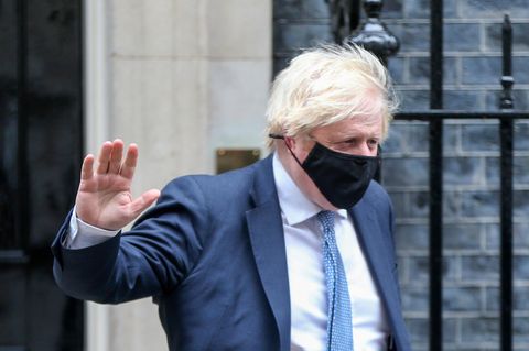 Boris Johnson hebt eine Hand im Vorbeigehen