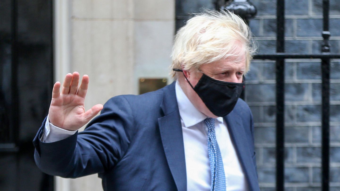 Boris Johnson hebt eine Hand im Vorbeigehen