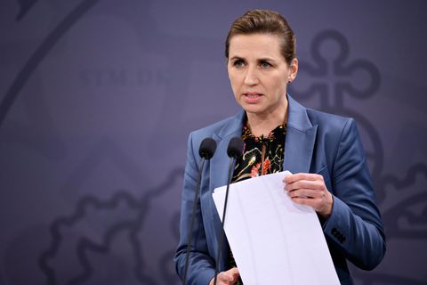 Die dänische Ministerpräsidentin Mette Frederiksen hält ein Blatt Papier in der Hand