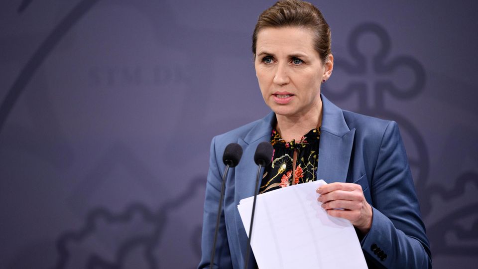 Die dänische Ministerpräsidentin Mette Frederiksen hält ein Blatt Papier in der Hand