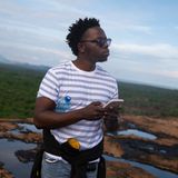 Andrew Gwadiva steht auf dem Felsen im Zentrum von Kinakoni