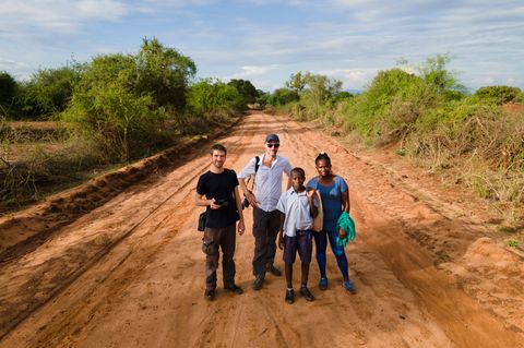 Das stern-Team vor Ort in Kinakoni: Fotograf Jonas Wresch (l.) und stern-Projektleiter Marc Goergen. Neben ihnen der Schüler Mutati Makali Kilii und die Dorfchefin Josephine Mbuwi.