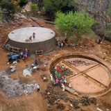 Männer und Frauen aus Kinakoni arbeiten an zwei jeweils 225 Kubikmeter fassenden Wassertanks