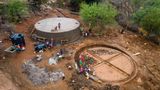 Männer und Frauen aus Kinakoni arbeiten an zwei jeweils 225 Kubikmeter fassenden Wassertanks