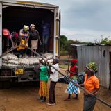 Dorfbewohner entladen Armiereisen aus einem Lkw