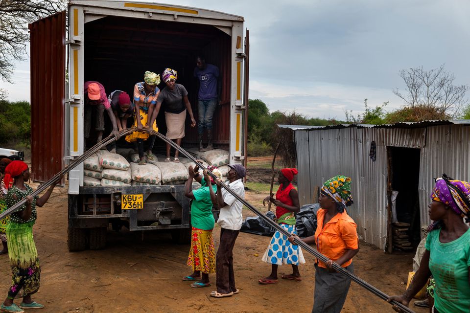 Dorfbewohner entladen Armiereisen aus einem Lkw