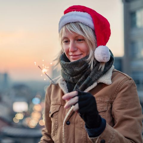 Frau wünscht sich etwas mit einer Wunderkerze in der Hand