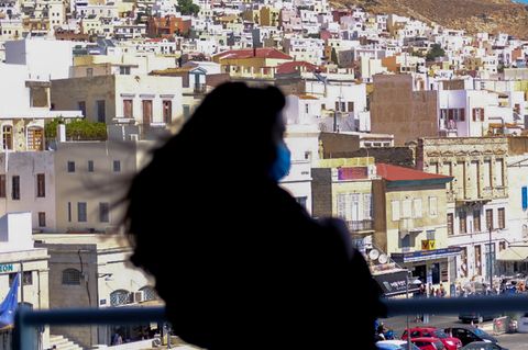 Frau mit Mundschutz beim Anlegen der Fähre auf einer Kykladeninsel