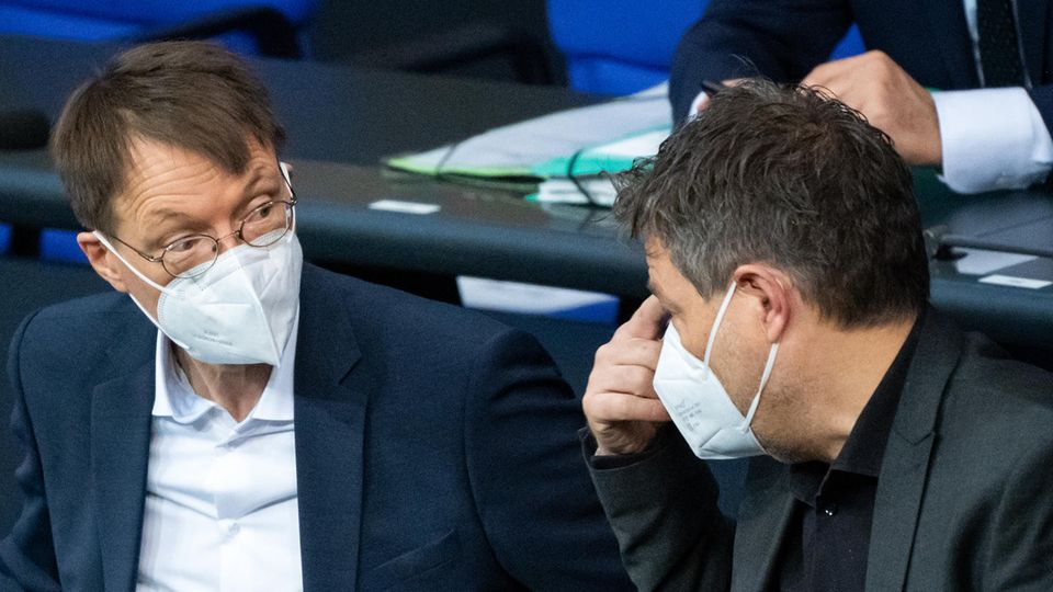Bundesgesundheitsminister Karl Lauterbach (l., SPD) und Wortschaftsminister Robert Habeck (Bündnis 90/Die Grünen) unterhalten sich bei der Plenarsitzung im Deutschen Bundestag auf der Regierungsbank