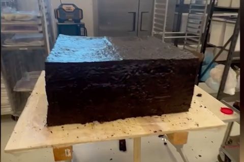 Ein riesiger Brownie steht auf einem Tisch in einer Bäckerei.