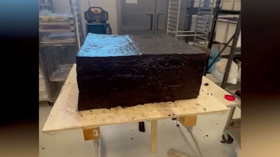 Ein riesiger Brownie steht auf einem Tisch in einer Bäckerei.