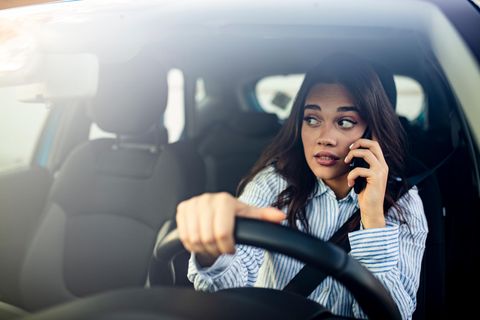 Eine Frau telefoniert am Steuer eines Pkw