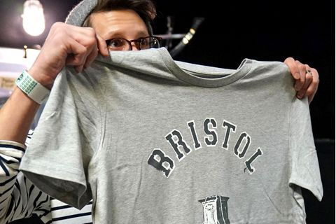 Ein Kunde hält ein von Banksy entworfenes T-Shirt hoch