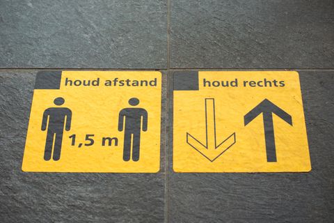 Ein Straßenaufdruck in der Niederlanden, der Coronaregeln erklärt