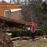 Ein Bewohner von Dickson telefoniert und begutachtet die Schäden vor seinem Haus
