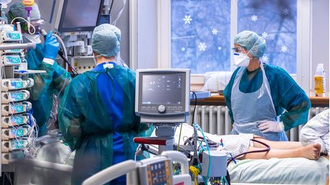 Ärzte und Pflegekräfte betreuen einen Patienten auf der Intensivstation in der Universitätsmedizin Rostock