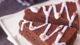 Spiced Brownies      Zutaten: 150 g Butter, 150 g Zartbitter-Schokolade, 3 Eier, 150 g Zucker, 1 Päckchen Vanillezucker, 1 TL Zimt, je 1 Prise Salz, gemahlene Muskatnuss und gemahlene Gewürznelken, 1 unbehandelte Orange, Abrieb, 2 EL Rotwein oder Portwein, 125 g Mehl, ¼ TL Backpulver  Für die Dekoration: 75 g Puderzucker, 2–3 TL Wasser Zuckerstreusel      Zutaten:  Eine runde Springform von 24–26 cm Durchmesser gründlich ausfetten, beiseitestellen. Für den Teig Butter und Schokolade unter Rühren in einem kleinen Topf schmelzen, 10 Minuten abkühlen lassen. Den Backofen auf 190 °C Ober-/Unterhitze vorheizen. Eier mit Zucker, Vanillezucker und Gewürzen kurz verquirlen. Den Rotwein und die Schokoladenmischung dazurühren, anschließend das Mehl mit dem Backpulver unterheben – nur so lange rühren, bis sich alles vermischt hat, aber nicht lange schlagen. Den Teig in die vorbereitete Form füllen und glatt streichen. 22–25 Minuten backen – der Kuchen darf in der Mitte noch ganz leicht feucht sein. Brownies in der Form auf einem Rost auskühlen lassen. Für die Dekoration in der Zwischenzeit Puderzucker mit Wasser zu einem sehr dicken Guss verrühren. Brownies aus der Form nehmen und in 12 spitze Dreiecke schneiden, unten begradigen, wenn erforderlich. Zuckerguss in einen Plastikbeutel füllen, unten eine kleine Spitze abschneiden. Guss im Zickzack wie eine Girlande auf die dreieckigen "Tannenbäume" spritzen, mit Zuckerstreuseln bestreuen.
