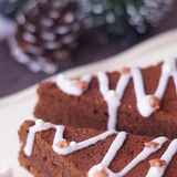 Spiced Brownies      Zutaten: 150 g Butter, 150 g Zartbitter-Schokolade, 3 Eier, 150 g Zucker, 1 Päckchen Vanillezucker, 1 TL Zimt, je 1 Prise Salz, gemahlene Muskatnuss und gemahlene Gewürznelken, 1 unbehandelte Orange, Abrieb, 2 EL Rotwein oder Portwein, 125 g Mehl, ¼ TL Backpulver  Für die Dekoration: 75 g Puderzucker, 2–3 TL Wasser Zuckerstreusel      Zutaten:  Eine runde Springform von 24–26 cm Durchmesser gründlich ausfetten, beiseitestellen. Für den Teig Butter und Schokolade unter Rühren in einem kleinen Topf schmelzen, 10 Minuten abkühlen lassen. Den Backofen auf 190 °C Ober-/Unterhitze vorheizen. Eier mit Zucker, Vanillezucker und Gewürzen kurz verquirlen. Den Rotwein und die Schokoladenmischung dazurühren, anschließend das Mehl mit dem Backpulver unterheben – nur so lange rühren, bis sich alles vermischt hat, aber nicht lange schlagen. Den Teig in die vorbereitete Form füllen und glatt streichen. 22–25 Minuten backen – der Kuchen darf in der Mitte noch ganz leicht feucht sein. Brownies in der Form auf einem Rost auskühlen lassen. Für die Dekoration in der Zwischenzeit Puderzucker mit Wasser zu einem sehr dicken Guss verrühren. Brownies aus der Form nehmen und in 12 spitze Dreiecke schneiden, unten begradigen, wenn erforderlich. Zuckerguss in einen Plastikbeutel füllen, unten eine kleine Spitze abschneiden. Guss im Zickzack wie eine Girlande auf die dreieckigen "Tannenbäume" spritzen, mit Zuckerstreuseln bestreuen.