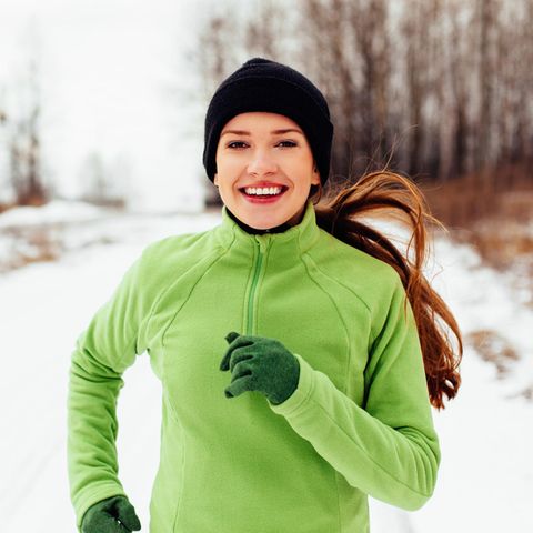 Eine Frau joggt im Schnee