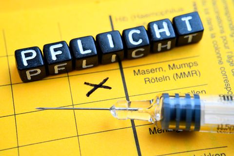 Impfausweis mit angekreuzter Masern-Impfung und Schriftzug Pflicht, Masern-Impfpflicht