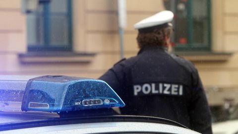 Bayern: Ein Polizist vor einem Polizeiauto (Symbolbild)