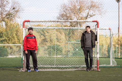 Zwei Männer stehen rechts und links an ein Fußballtor gelehnt