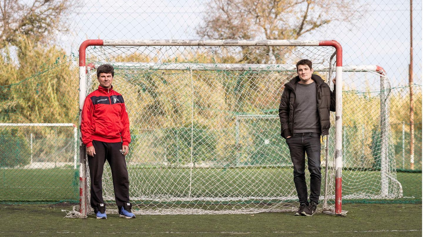 Zwei Männer stehen rechts und links an ein Fußballtor gelehnt