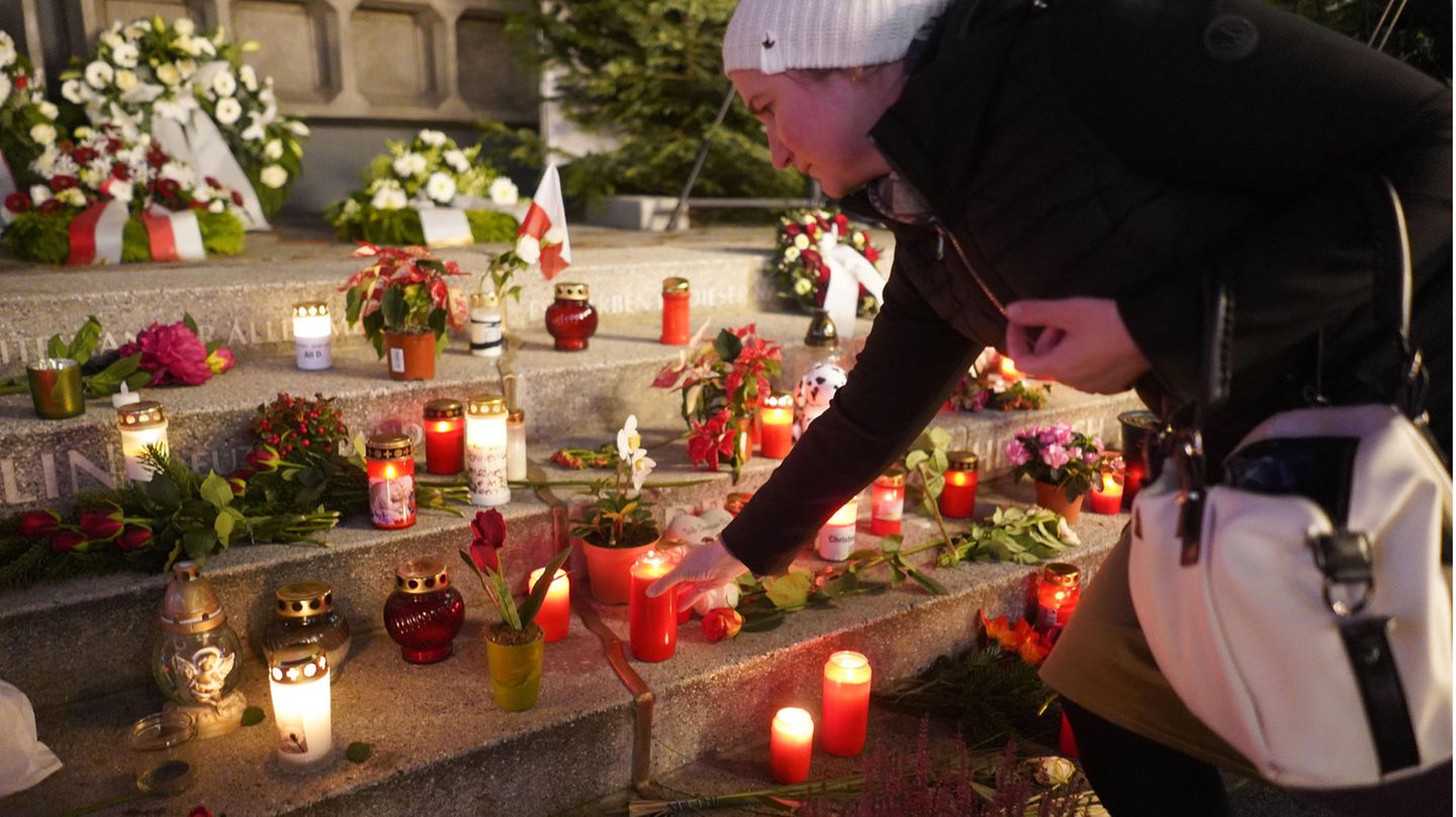 Eine Frau stellt eine Gedenkkerzen zu vielen anderen auf dem Breitscheidplatz Berlin