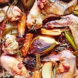 Schritt 1: Den Backofen auf 180 °C vorheizen. Die Zwiebeln schälen, die Möhren waschen, beides sowie Sellerie und Speck grob hacken. Gemüse, Lorbeer, Salbei, Rosmarin und Sternanis in einen hohen Bräter geben und mit dem Speck bestreuen. Die Hähnchenflügel aufbrechen, mit einem Nudelholz klopfen, damit sie beim Garen mehr Aroma abgeben, und in den Bräter füllen. Mit Öl beträufeln, mit Meersalz und schwarzem Pfeffer bestreuen. Mischen und 1 Stunde rösten.