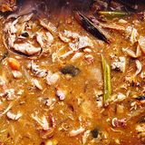 Schritt 2: Den Bräter aus dem Ofen nehmen. Auf den Herd setzen und schwache Hitze einstellen. Alles mit einem Kartoffelstampfer kräftig zerdrücken, dabei den Bratensatz losschaben (je länger alles röstet, desto dunkler wird die Sauce). Wer mag, gibt nun Sherry oder Portwein dazu und lässt ihn kurz verkochen. Nach und nach das Mehl unterrühren, dann 2 l kochend heißes Wasser in den Bräter gießen. Die Sauce unter gelegentlichem Rühren 30 Minuten köcheln lassen, bis sie reduziert und dicklich ist.  Schritt 3: Wenn die Konsistenz stimmt, die Sauce durch ein Sieb in eine Schüssel gießen. Die Rückstände im Sieb mit einem Löffelrücken kräftig ausdrücken. Die Sauce mit Salz und Pfeffer abschmecken. Auf Zimmertemperatur abkühlen lassen, dann in Gefrierdosen oder -beutel füllen und kaltstellen oder einfrieren.