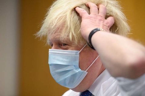 Boris Johnson trägt Maske und fässt sich an den Kopf