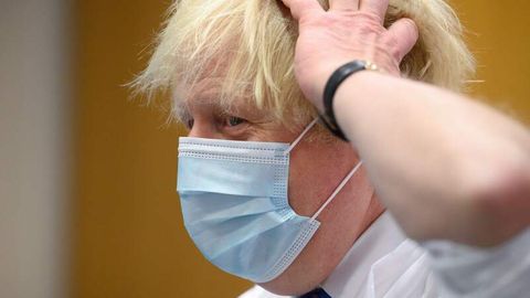 Boris Johnson trägt Maske und fässt sich an den Kopf
