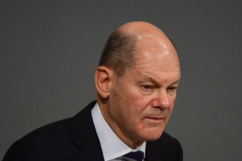Olaf Scholz in Anzug und Krawatte vor einem dunkelgrauen Hintergrund