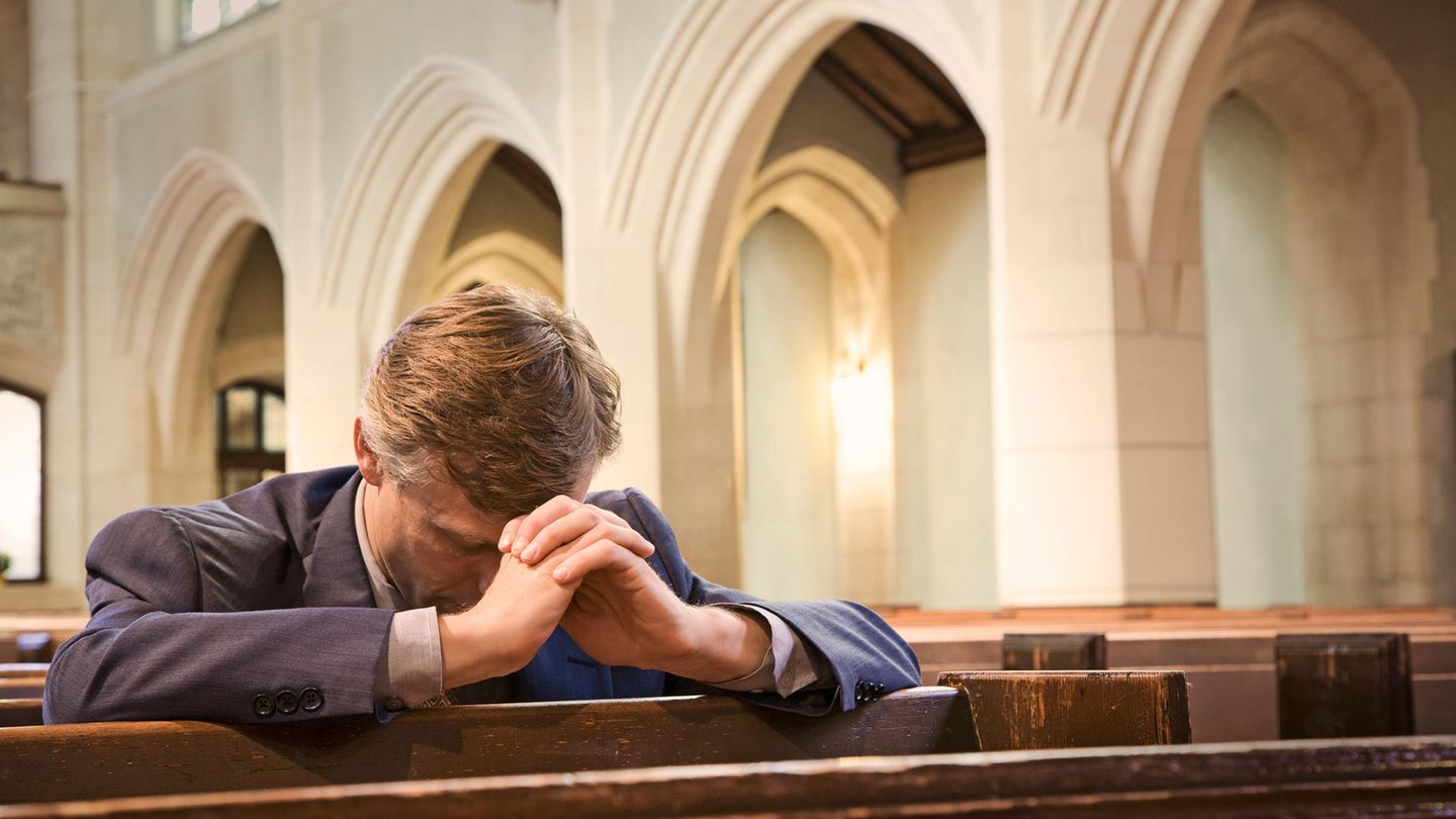 Mann betet in einer Kirche