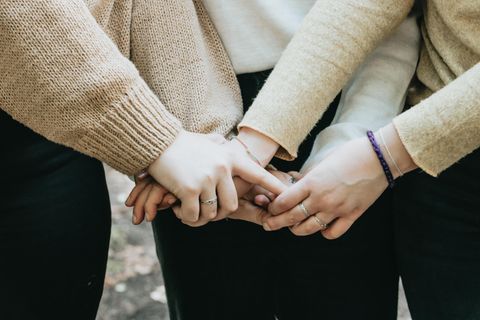 Drei Frauen halten sich an den Händen