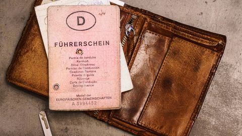 Ein alter Führerschein liegt auf einem Porte­mon­naie