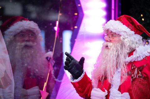 Ein als Weihnachtsmann verkleideter Mann steht vor dem Schaufenster des Kaufhauses Selfridges
