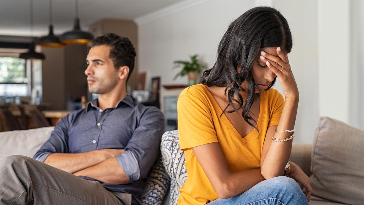 Pärchen sitzt auf einer Couch und wendet sich genervt voneinander ab