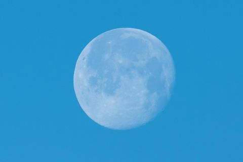 Der Mond leuchtet vor blauem Himmel