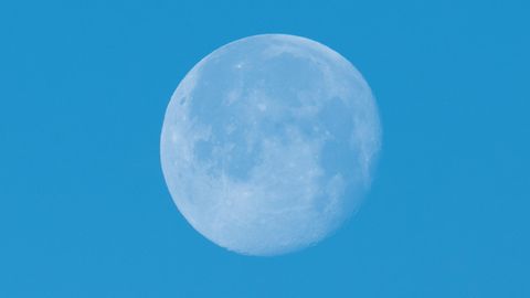 Der Mond leuchtet vor blauem Himmel