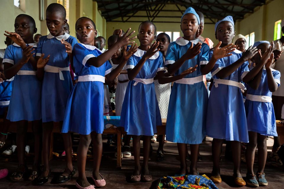 Eine Gruppe singender Schulmädchen in blauen Uniformen